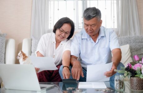Senior couple at home doing taxes together seated on a couch